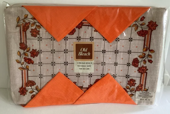 Floral table pieces and orange napkins