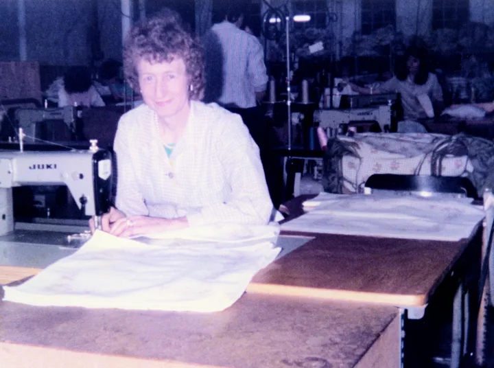 Kathleen Letters smiling at her Juki sewing machine in the Old Bleach Stitching Room in 1982
