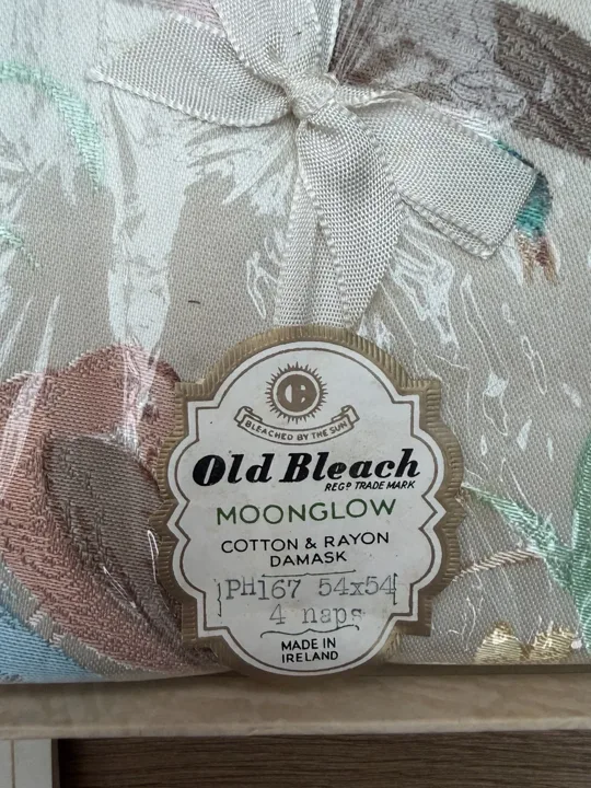 Old Bleach Moonglow tag attached to patterned cloth, marked cotton and rayon damask