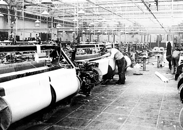 The weaving department of the Old Bleach Linen Company with workers attending rows of linen looms in 1938